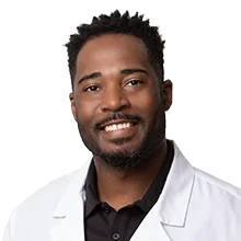 Dr. Ray Tucker, DDS, pediatric dentist in Las Vegas, smiling in a white coat